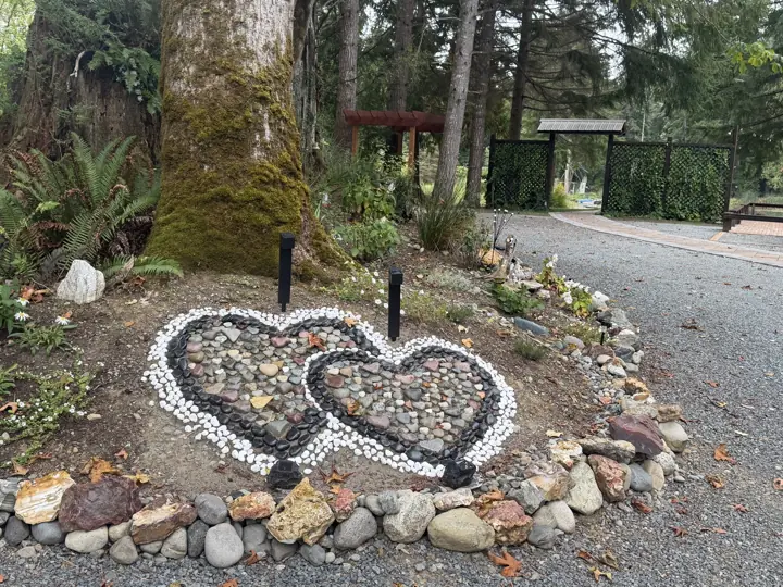 Double hearts set in river stone at the entry, with the Ivy Gate beyond