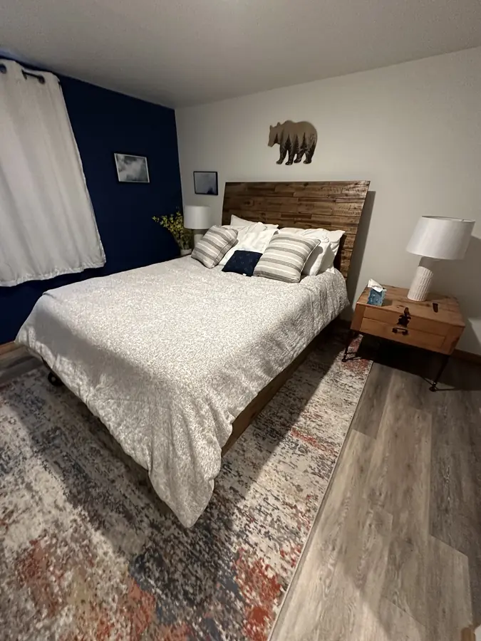 The master bedroom, with a queen bed and a navy accent wall
