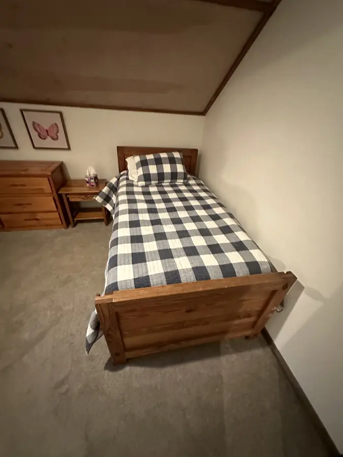 An upstairs twin bedroom with a navy check quilt