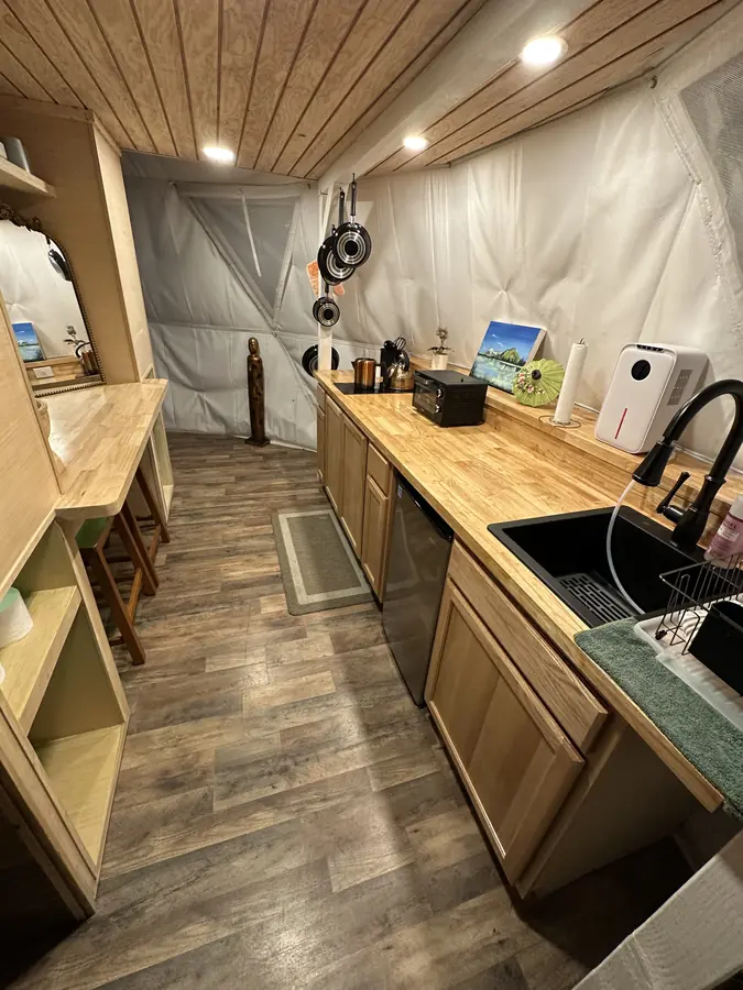 The Dragonfly Yurt kitchenette, with a butcher-block counter and sink