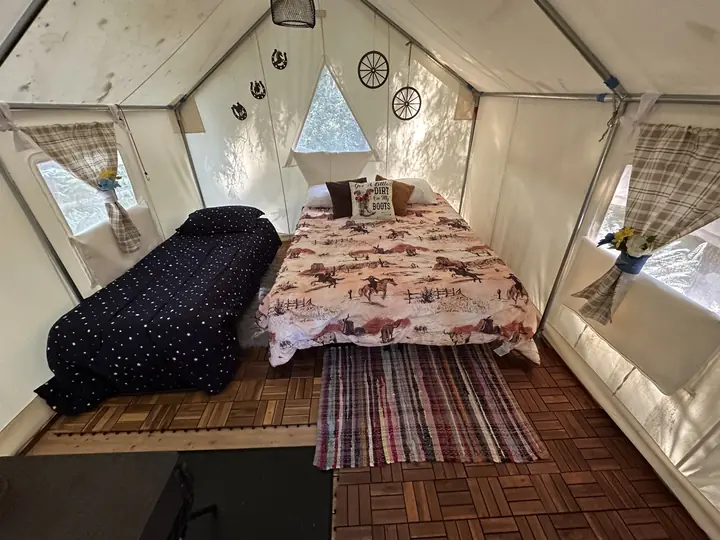 The western-themed tent, with a queen bed and a cot
