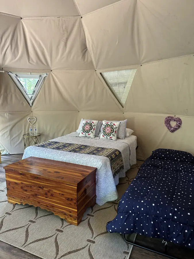 Inside the Honeybee Yurt: a bed with a cedar chest at its foot, and a cot for a third guest