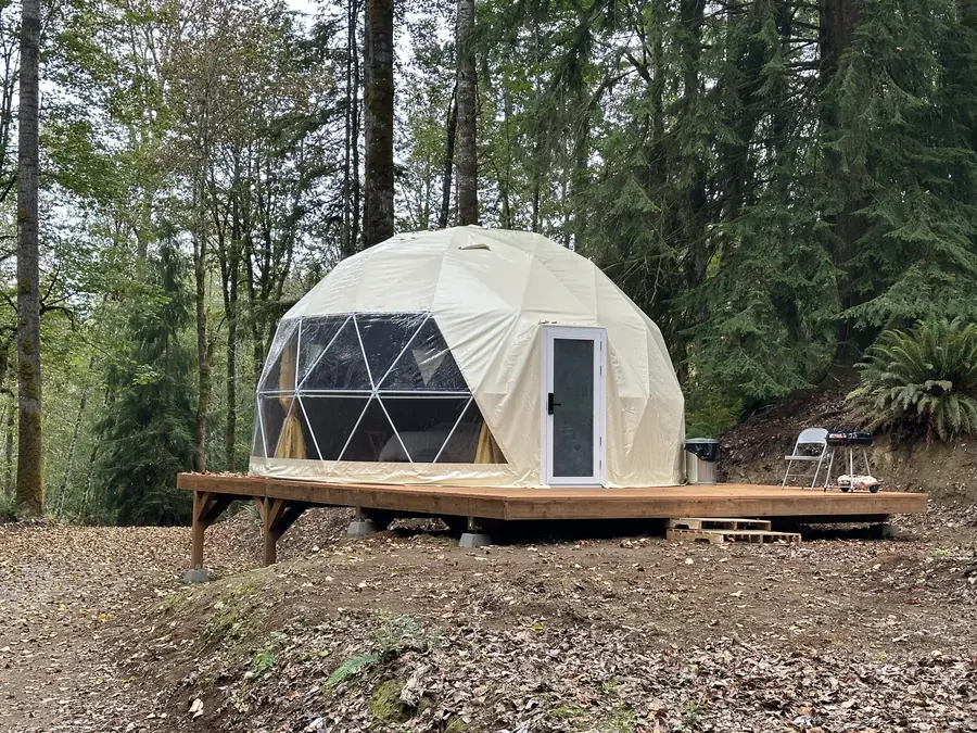 The Honeybee Yurt: a geodesic dome on a wooden deck among the cedars