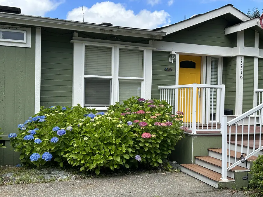 The Lake House front porch, with its yellow door and hydrangeas in bloom