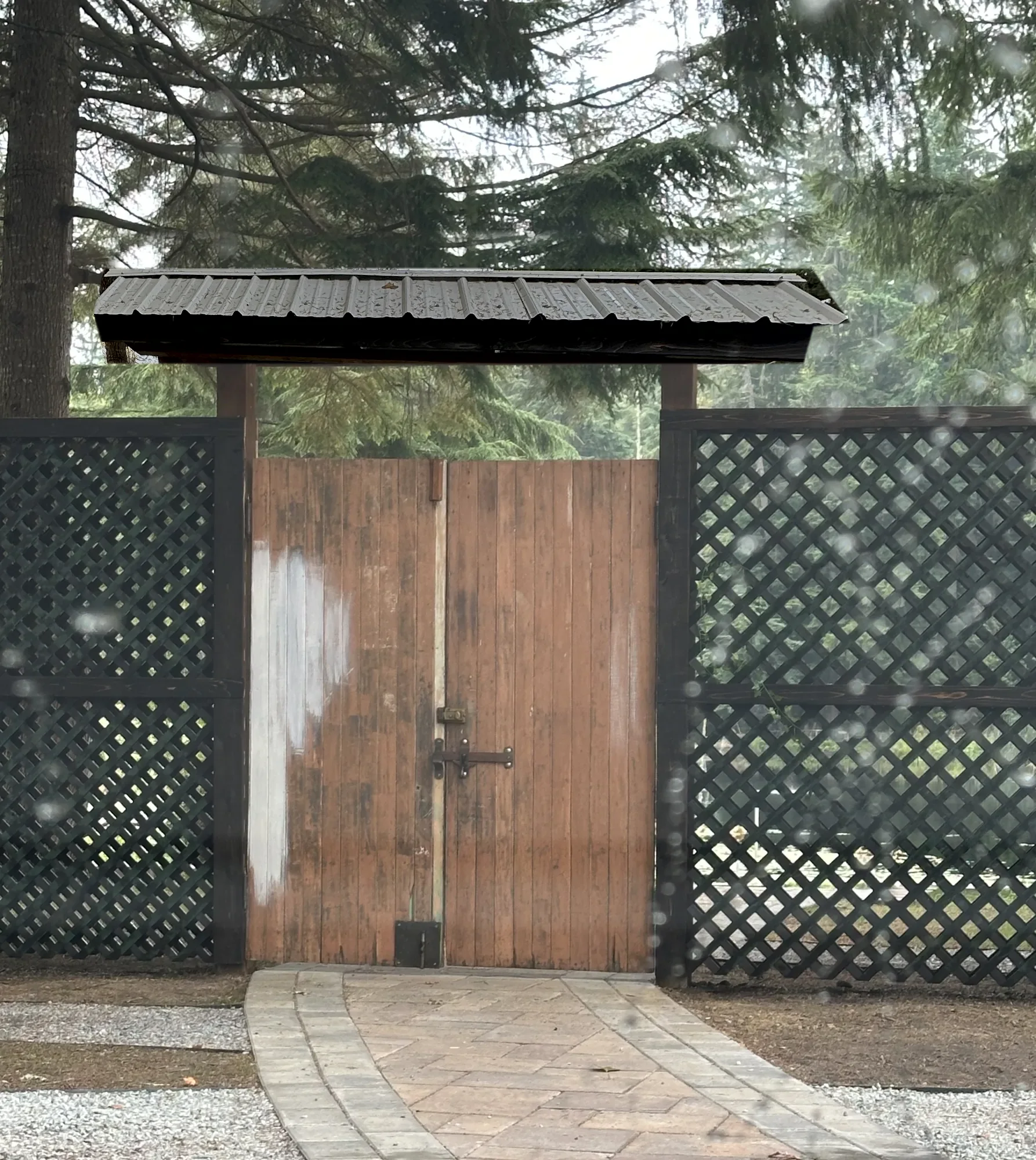 The Ivy Gate today: a timber-frame gate with lattice panels and a weathered wooden door