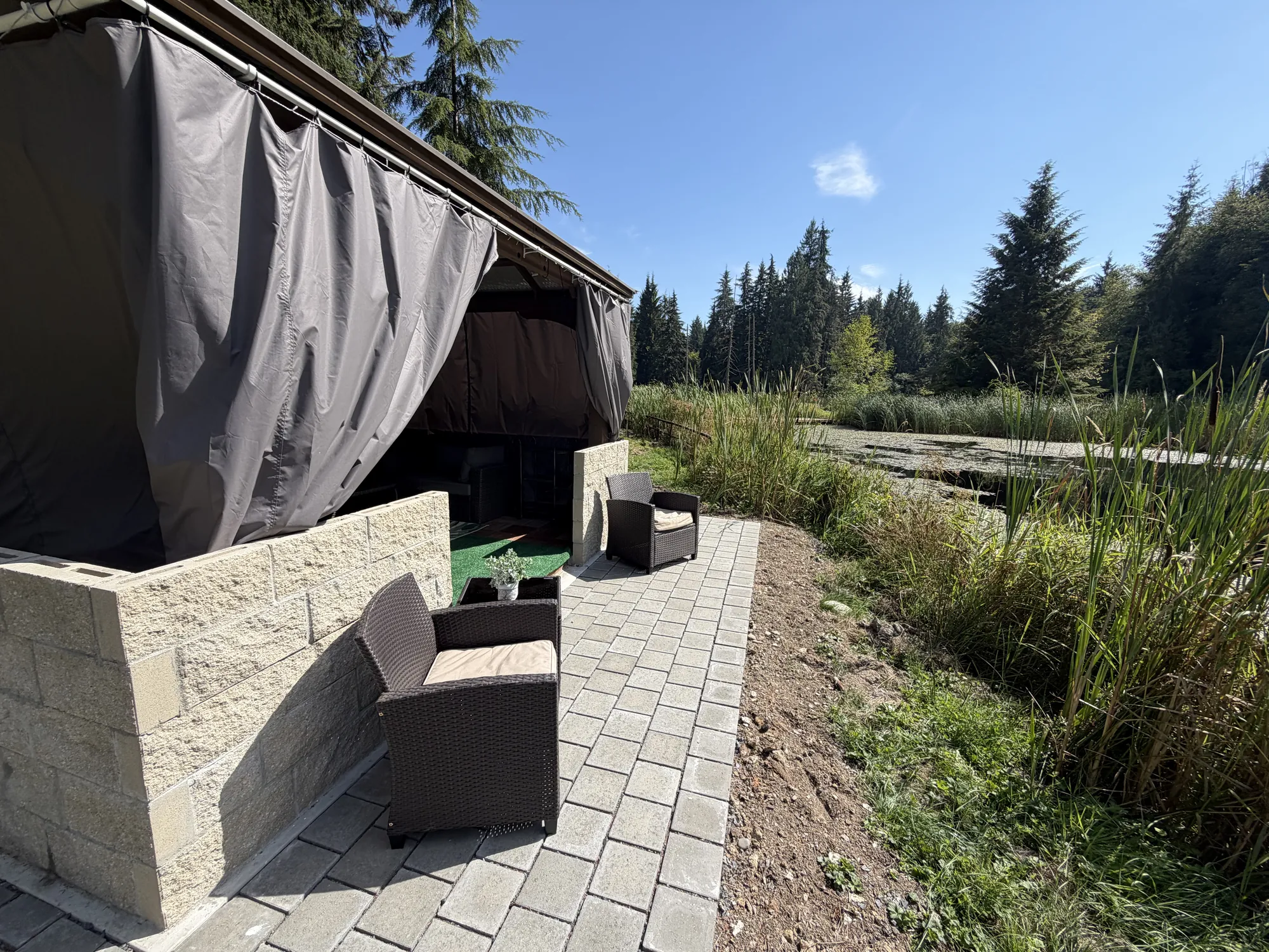The Lounge, a curtained cabana with lounge seating beside the lake